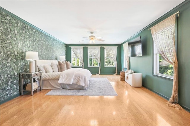 bedroom with multiple windows, hardwood / wood-style flooring, ceiling fan, and ornamental molding