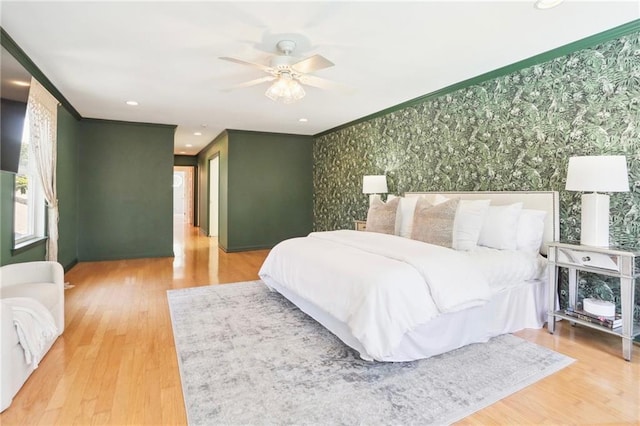 bedroom featuring ceiling fan, hardwood / wood-style floors, and ornamental molding