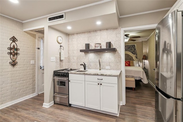 kitchen featuring stainless steel appliances, ceiling fan, white cabinetry, and dark hardwood / wood-style floors