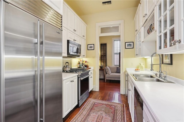 kitchen featuring dark hardwood / wood-style flooring, white cabinets, sink, and appliances with stainless steel finishes