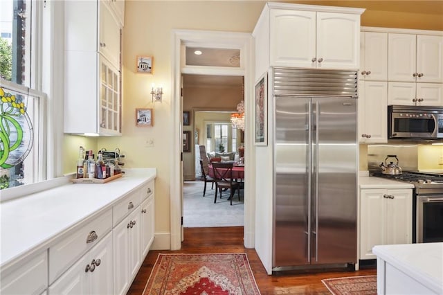 kitchen with appliances with stainless steel finishes, dark wood-type flooring, and white cabinetry