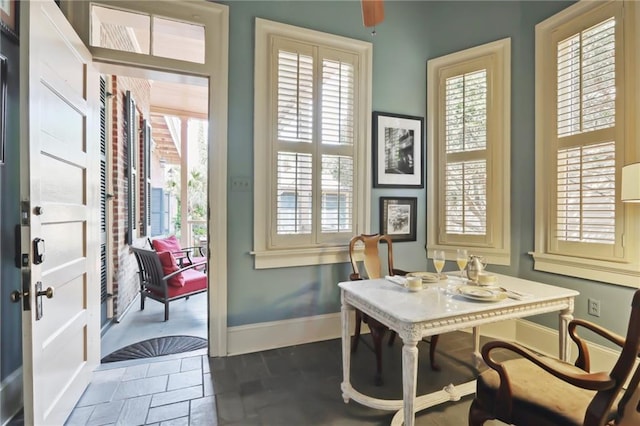 dining space with dark tile patterned floors and a healthy amount of sunlight