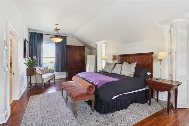 bedroom featuring lofted ceiling and dark hardwood / wood-style floors