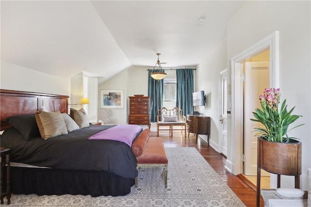 bedroom with lofted ceiling and wood-type flooring