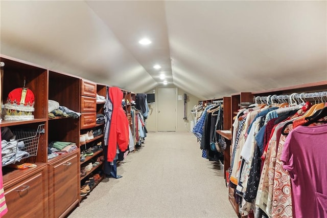 walk in closet with vaulted ceiling and light carpet