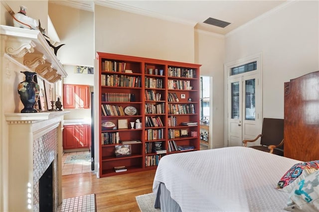 bedroom with light hardwood / wood-style flooring, crown molding, and a closet