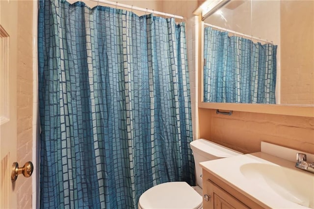 bathroom featuring toilet, a shower with shower curtain, and vanity