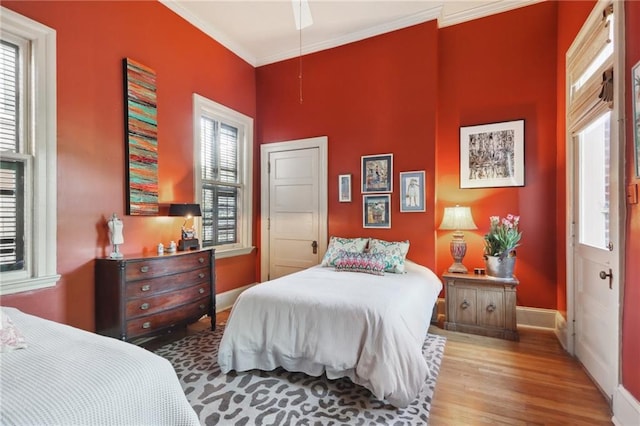 bedroom featuring hardwood / wood-style flooring, ornamental molding, and ceiling fan