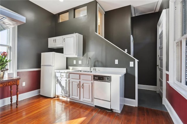 kitchen featuring premium range hood, dark wood-type flooring, white cabinets, sink, and white appliances