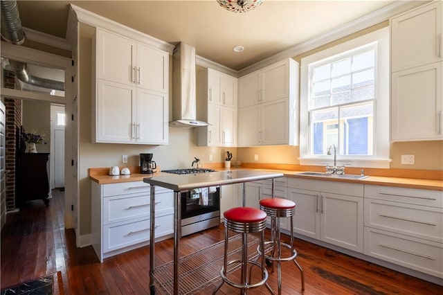 kitchen featuring white cabinets, dark hardwood / wood-style floors, wall chimney exhaust hood, and sink