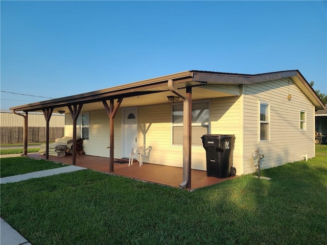 view of side of home with a patio and a lawn