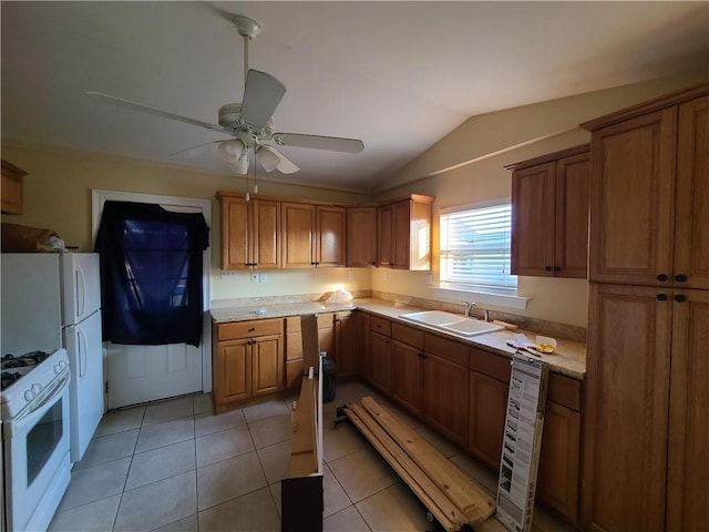 kitchen featuring white appliances, sink, ceiling fan, vaulted ceiling, and light tile patterned flooring