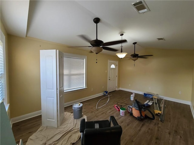 living room featuring visible vents, baseboards, and wood finished floors