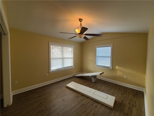 empty room with dark wood finished floors, lofted ceiling, a ceiling fan, and baseboards