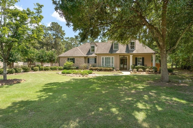 cape cod-style house featuring covered porch and a front lawn