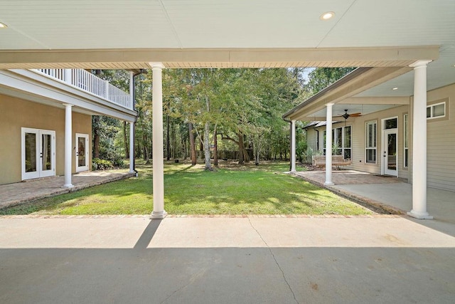 view of yard featuring ceiling fan, a patio, and french doors