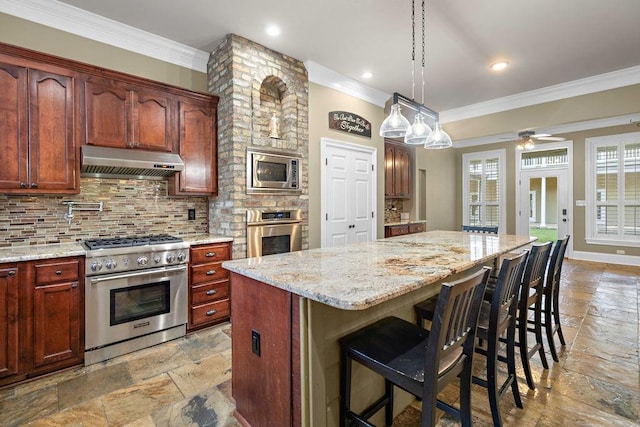 kitchen with ceiling fan, a kitchen breakfast bar, tasteful backsplash, light tile patterned floors, and stainless steel appliances