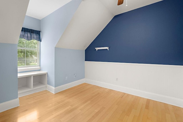 additional living space with ceiling fan, light wood-type flooring, lofted ceiling, and built in features