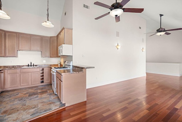 kitchen with decorative light fixtures, sink, high vaulted ceiling, wood-type flooring, and white appliances