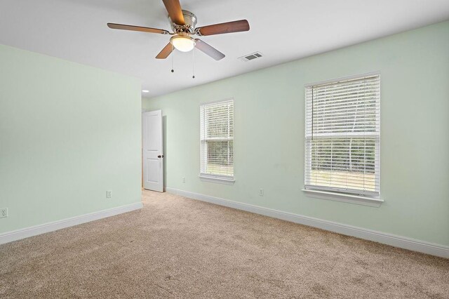 carpeted spare room featuring ceiling fan