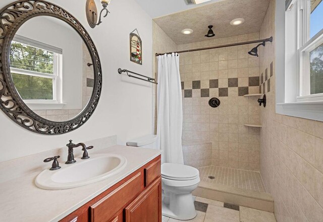 bathroom with toilet, vanity, walk in shower, and tile patterned floors