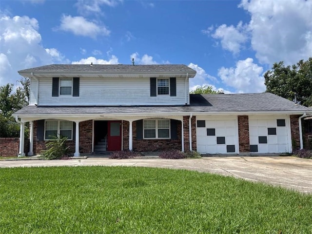 traditional-style home with a front yard, brick siding, driveway, and an attached garage