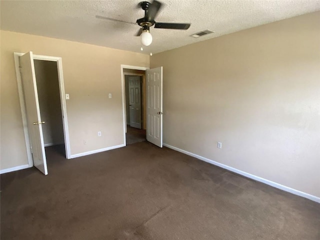 unfurnished bedroom featuring ceiling fan, a textured ceiling, and dark colored carpet