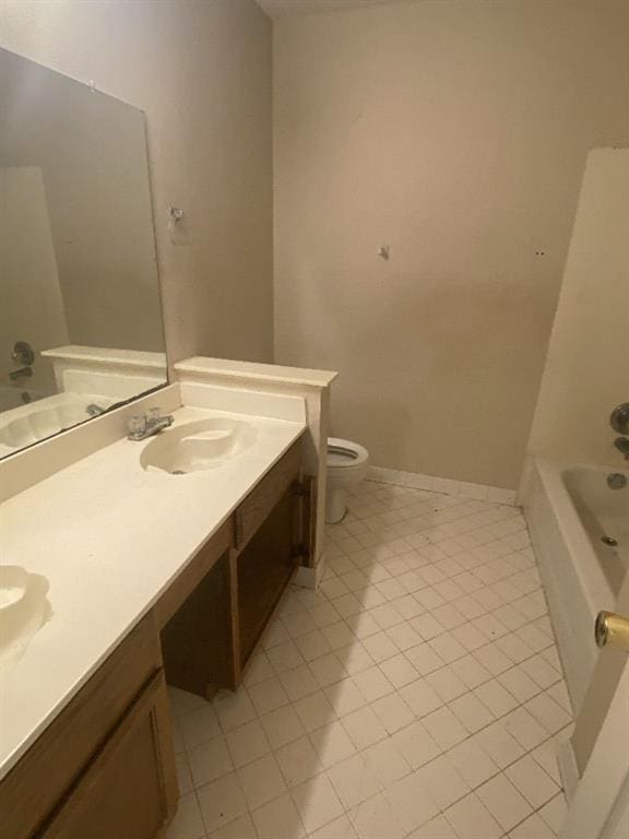 bathroom featuring tile patterned floors, toilet, vanity, and a tub to relax in