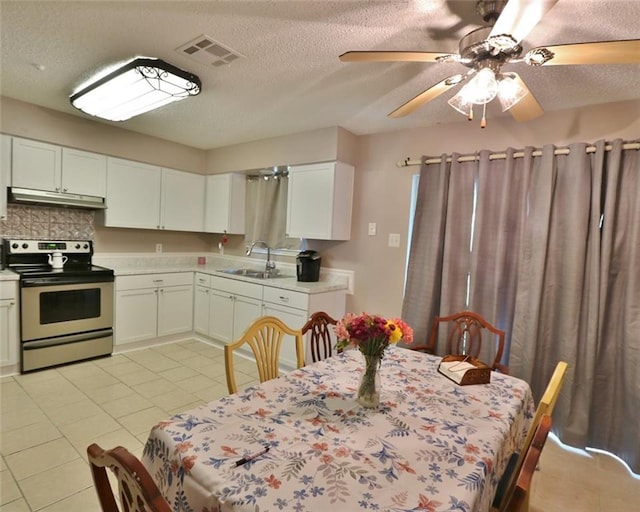 tiled dining area featuring sink, a textured ceiling, and ceiling fan