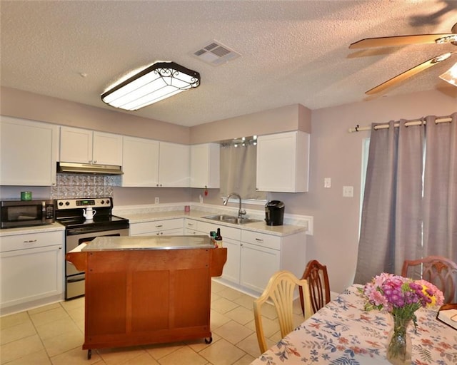 kitchen with sink, white cabinetry, ceiling fan, light tile patterned floors, and stainless steel appliances