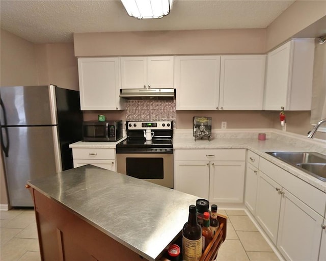 kitchen featuring sink, white cabinetry, a textured ceiling, light tile patterned floors, and stainless steel appliances