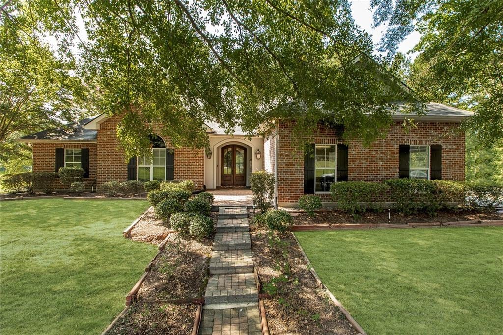 view of front of house with a front yard and french doors