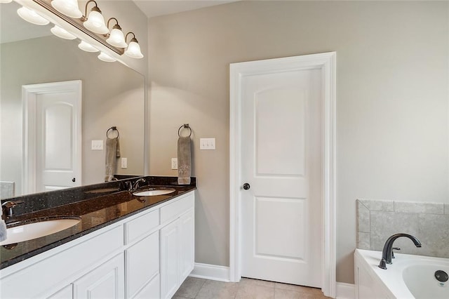 bathroom featuring tile patterned flooring, a bathtub, and vanity