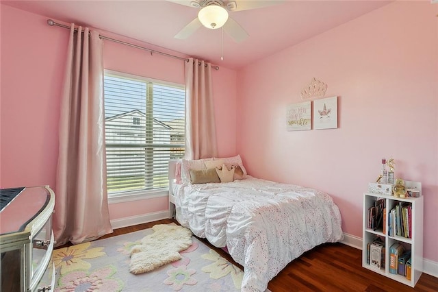 bedroom featuring ceiling fan, multiple windows, and dark hardwood / wood-style flooring