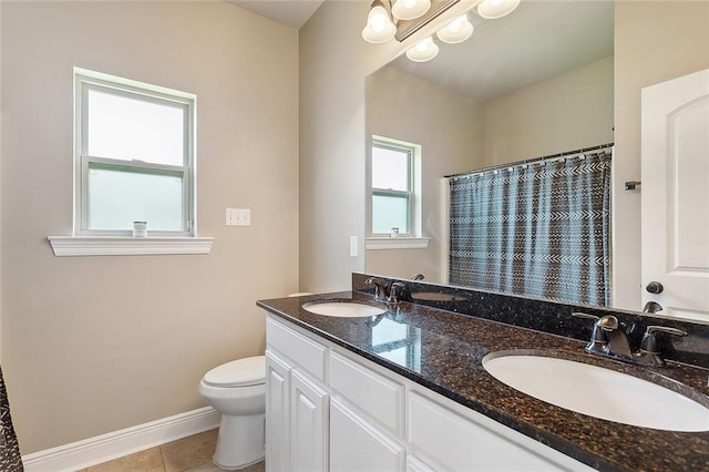 bathroom featuring toilet, a healthy amount of sunlight, vanity, and tile patterned floors