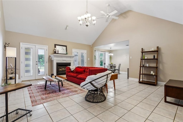 tiled living room with high vaulted ceiling, ceiling fan with notable chandelier, and french doors