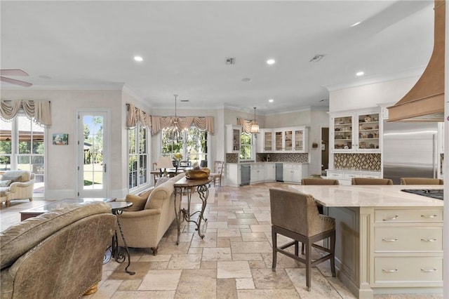 kitchen with stainless steel appliances, a kitchen breakfast bar, open floor plan, glass insert cabinets, and pendant lighting