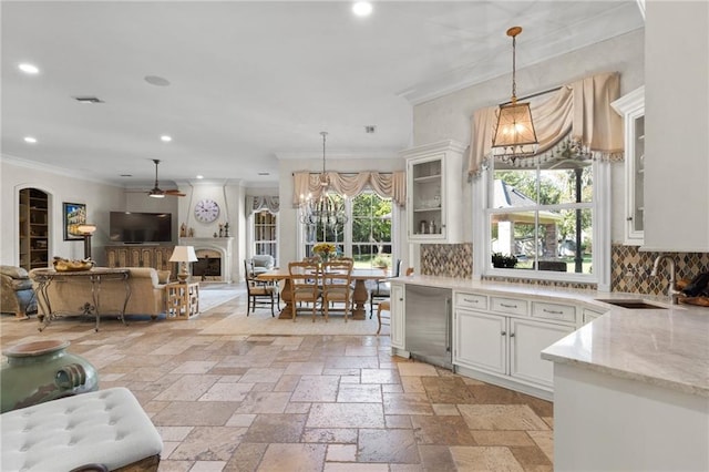 kitchen with light tile patterned flooring, hanging light fixtures, decorative backsplash, and white cabinetry