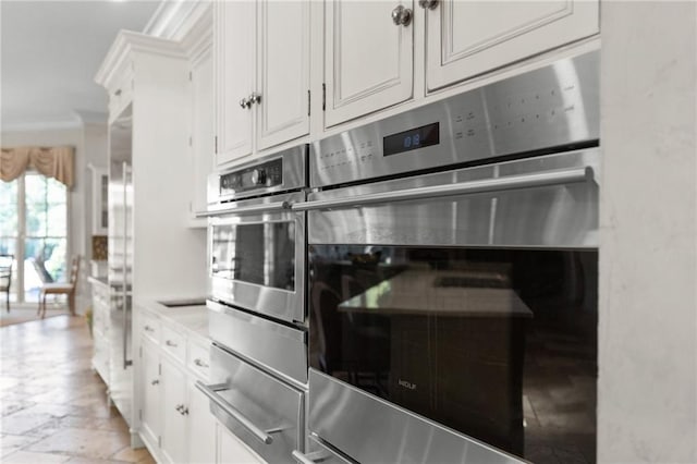 kitchen featuring marble finish floor, double oven, white cabinetry, and a warming drawer