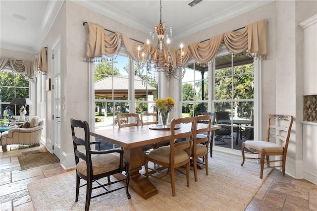 tiled dining space featuring an inviting chandelier, ornamental molding, and a healthy amount of sunlight