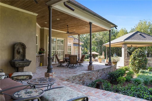 view of patio featuring a ceiling fan, outdoor dining space, and a gazebo