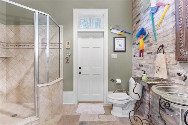 full bathroom with toilet, a stall shower, a sink, and stone tile flooring