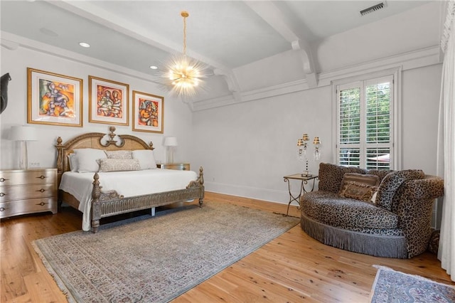 bedroom with beamed ceiling and light wood-type flooring