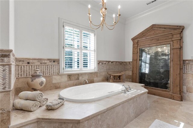 bathroom featuring tiled bath, crown molding, tile patterned flooring, and an inviting chandelier