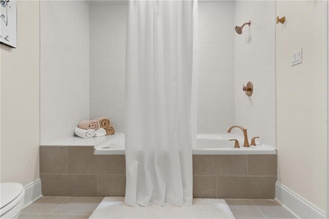 bathroom featuring tile patterned flooring, toilet, and shower / bath combo with shower curtain