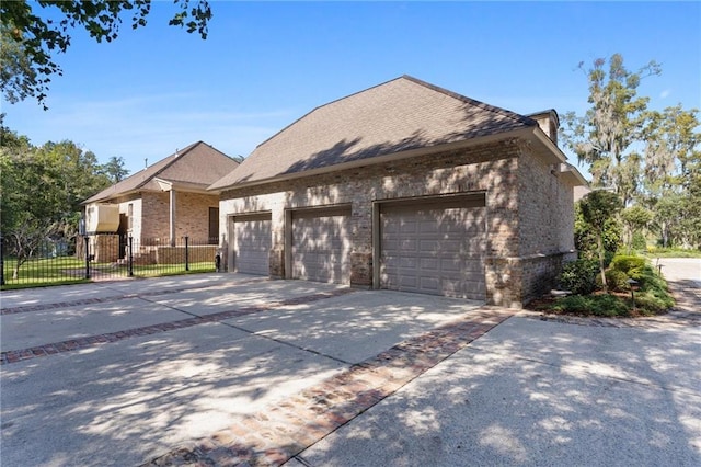 view of front facade with fence, concrete driveway, and brick siding