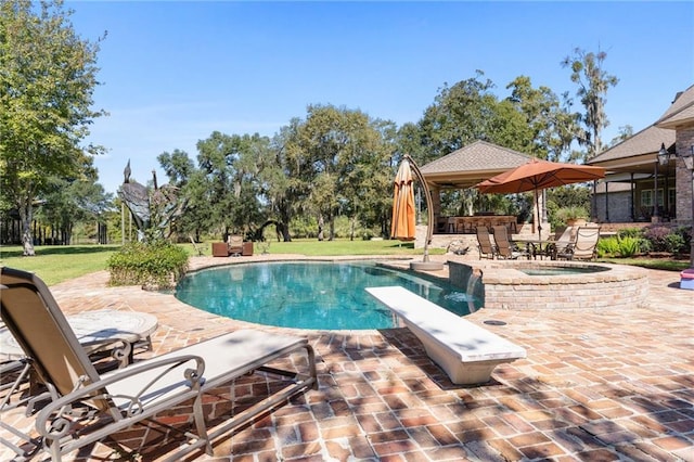 outdoor pool with a diving board, a patio, and an in ground hot tub