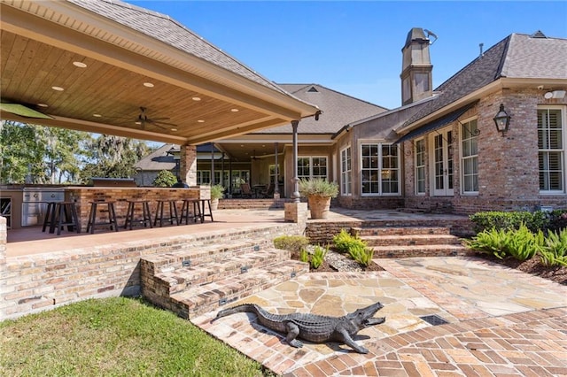 view of patio / terrace with ceiling fan and exterior bar