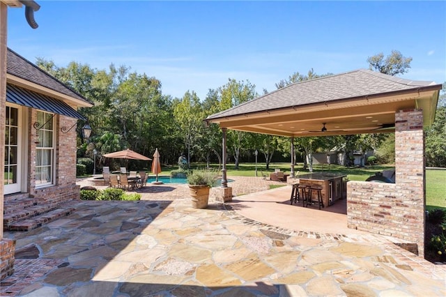 view of patio featuring ceiling fan, outdoor dry bar, and a gazebo