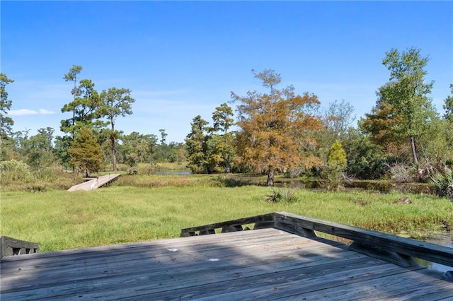 wooden terrace featuring a lawn